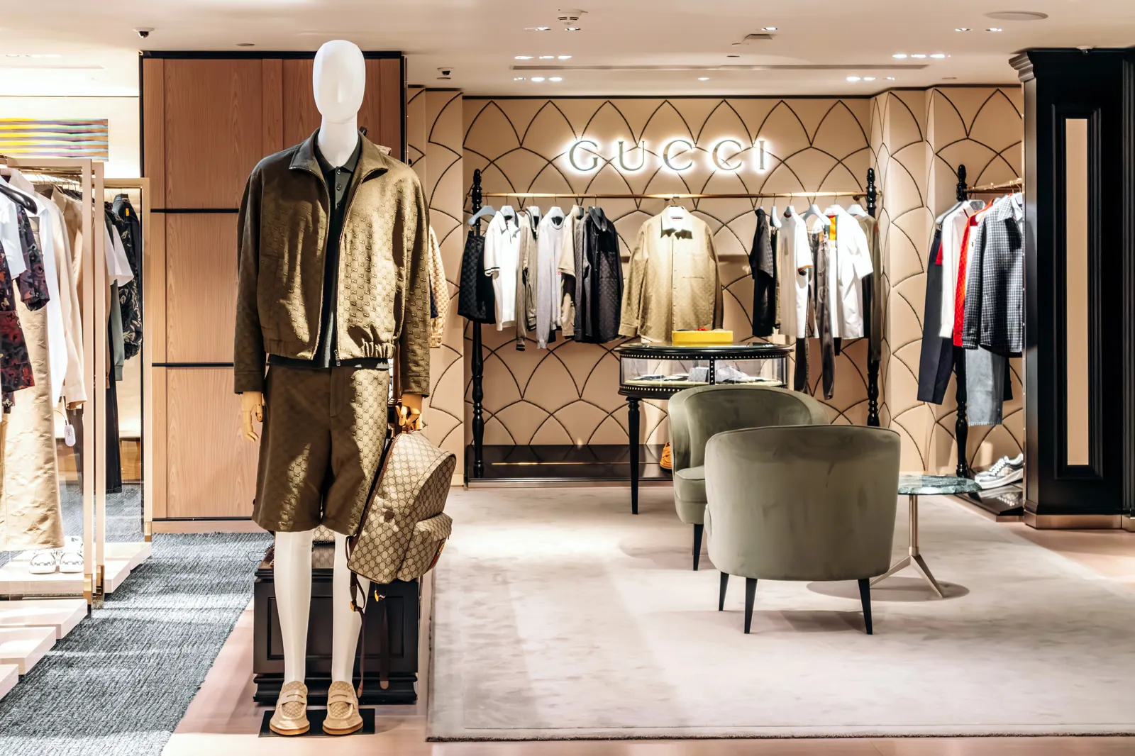 Boutique Gucci avec mise en scène mannequin et lounge — agencement retail luxe