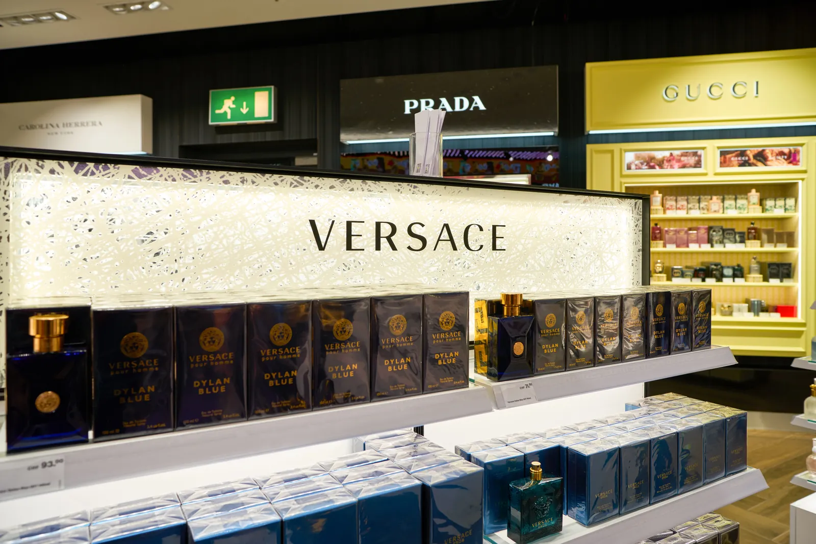 Mur de marque Versace en duty free — habillage retail premium